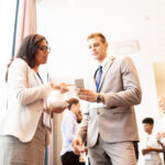 couple with smartphone at business conference