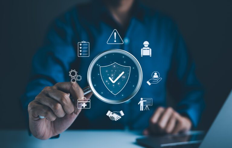 Businessman holding magnifying glass with icons work safety, compliance, risk management, and operational efficiency