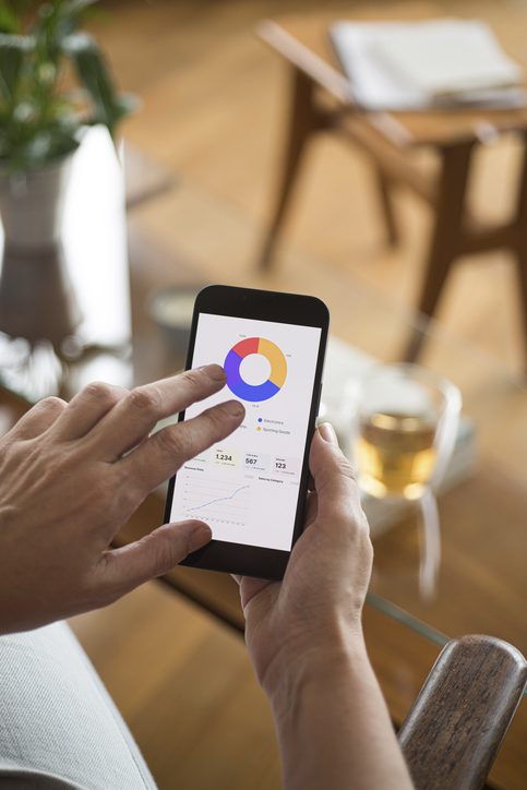 Woman using smart device for personal financial management.