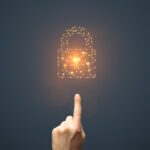 Network Security Artificial intelligence padlock symbol and finger touching it on dark background. This file is cleaned and retouched.