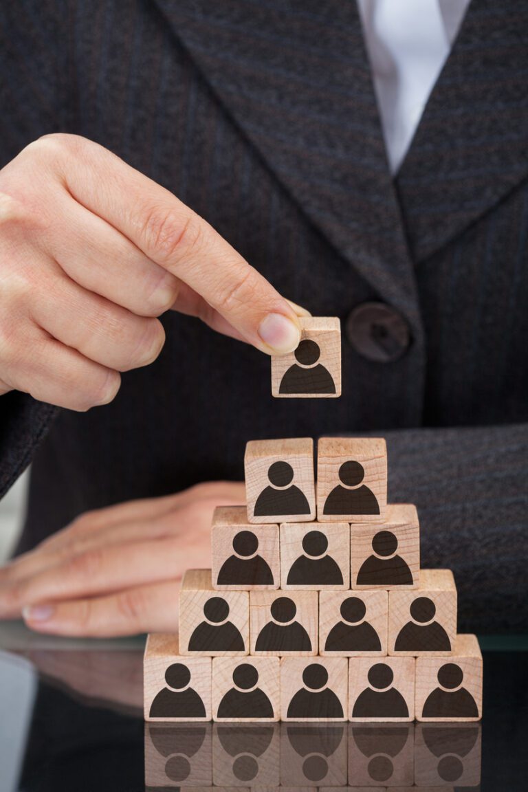 Midsection of businesswoman stacking wooden team blocks at table