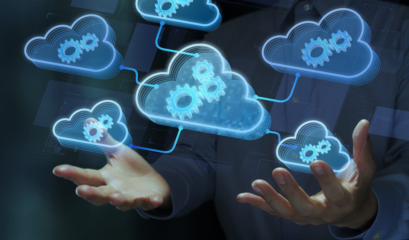 Business person holding cloud and gear icons.